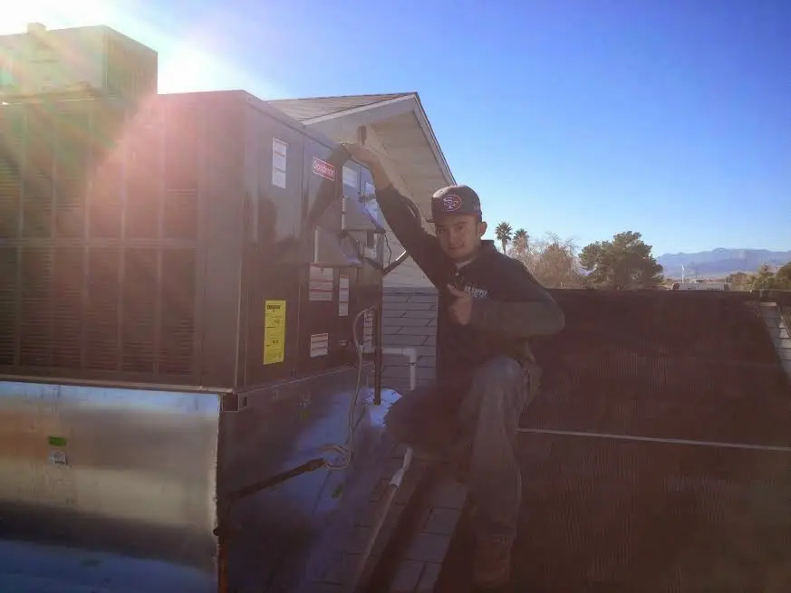 HVAC technician performing Air Duct Repair on a rooftop unit in Fort Payne